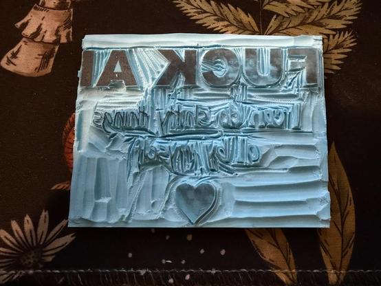 La petite plaque de gomme à graver avec « FUCK AI I can do shitty things all by myself » et un cœur gravés dessus.