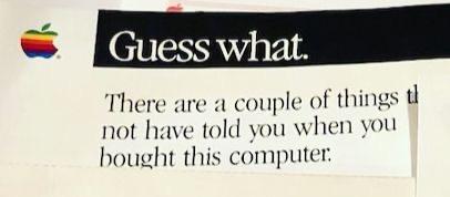 Apple rainbow logo on a printed piece of paper, with the text:
Guess what. There are a couple of things th... not have told you when you bought this computer.