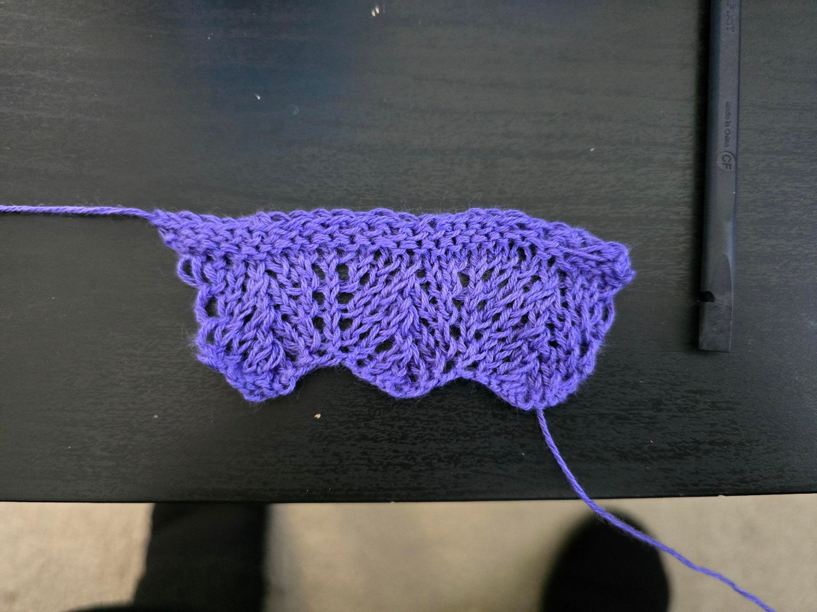 A three-time repeat of a rose-leaf lace pattern, knitted in purple yarn.